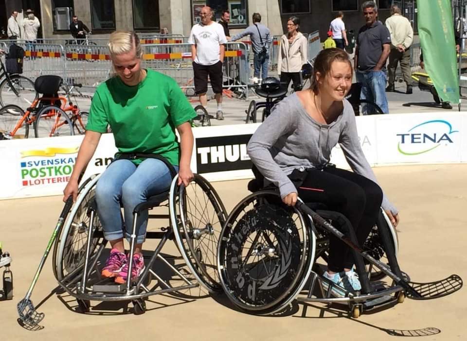 Två personer som provar rullstolsinnebandy